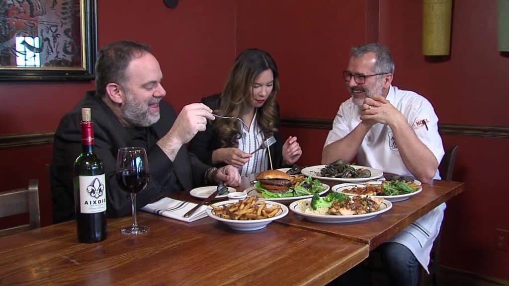 Two men and a woman eating in a restaurant