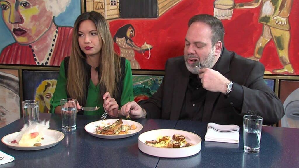 A man and a woman eating at a restaurant