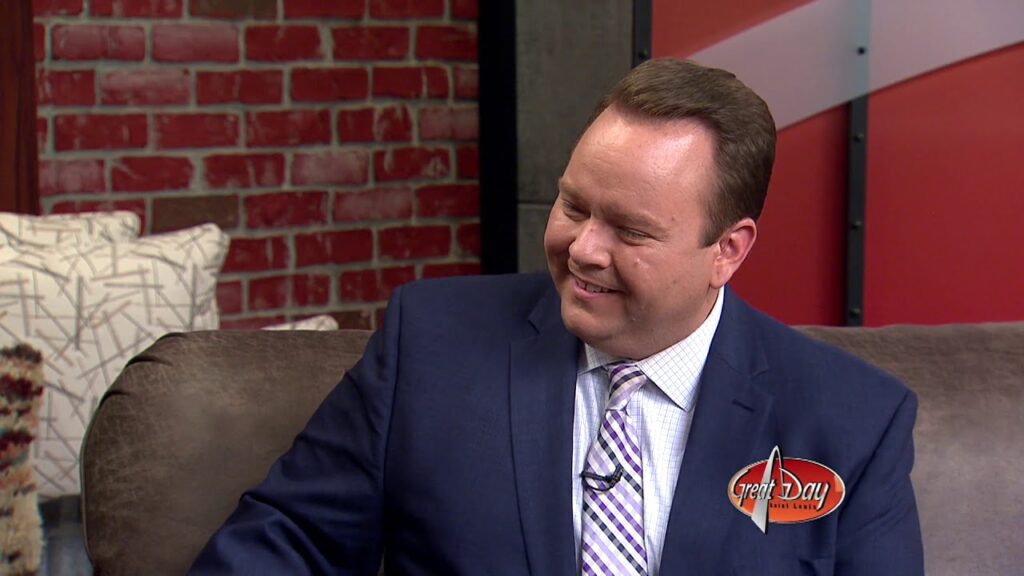 A man with a blue suit smiling