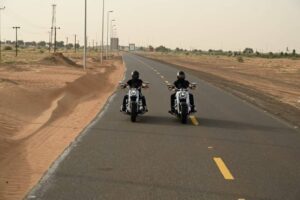 two motorcyclists on a desert highway