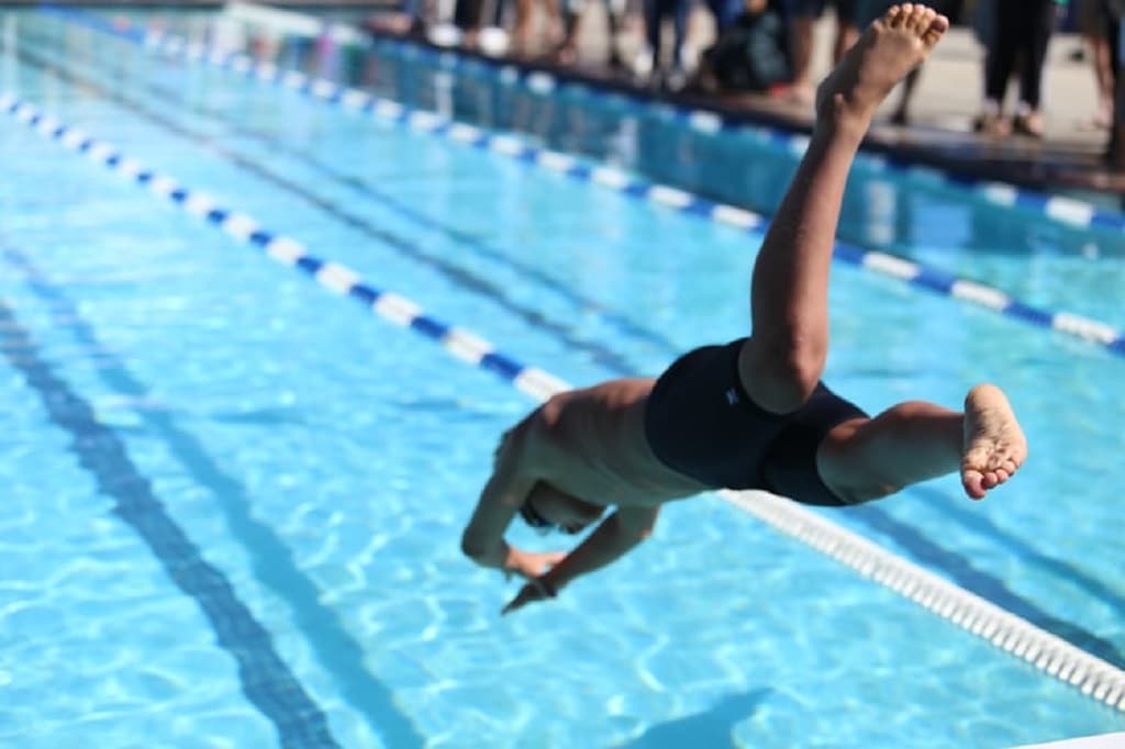 white man diving into a pool