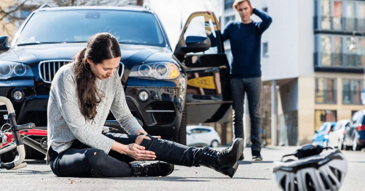 woman hlding knee after being hit by a car