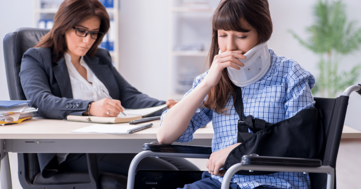 white woman in wheel chair with a neck brace talking to lawyer