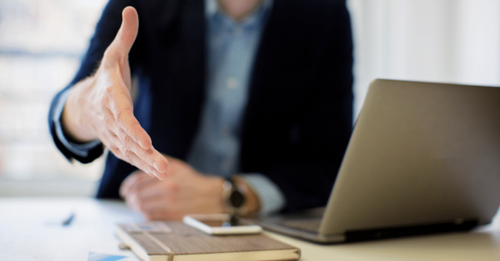 man reaching over to shake hand