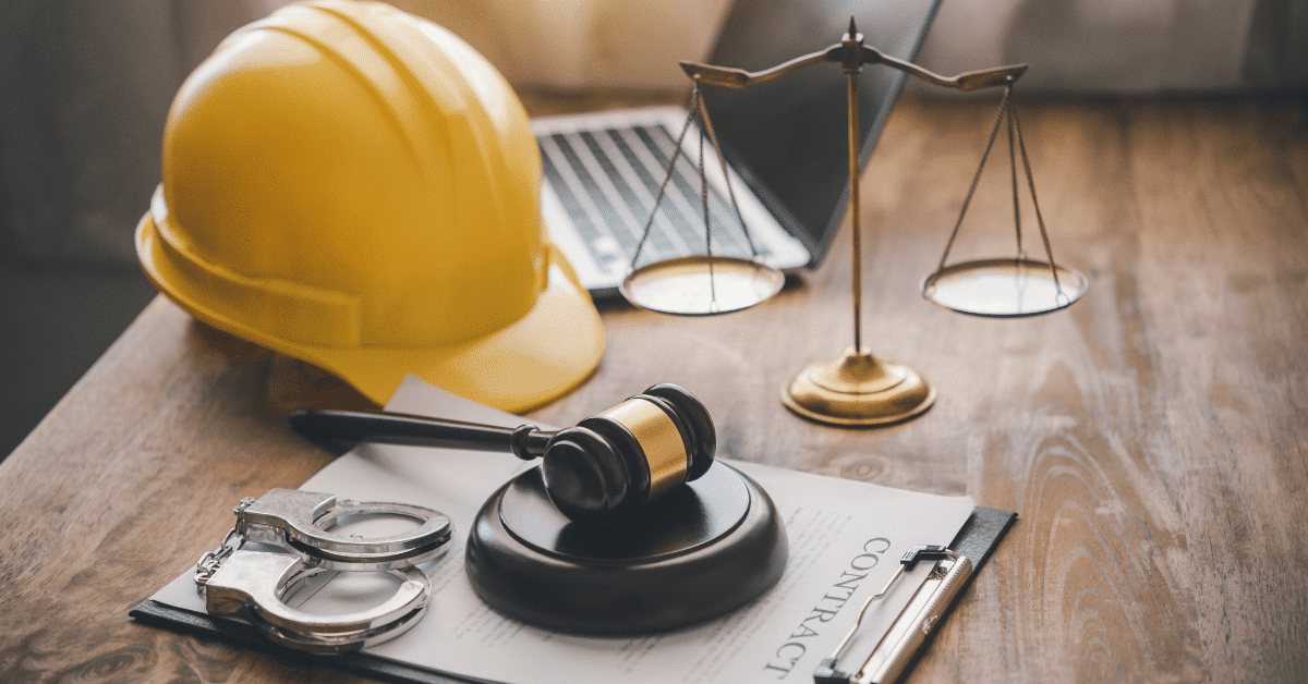 gavel, hard hat, and hand cuffs on table