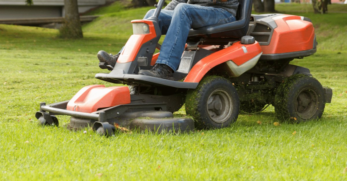 man sitting on red lawn mower