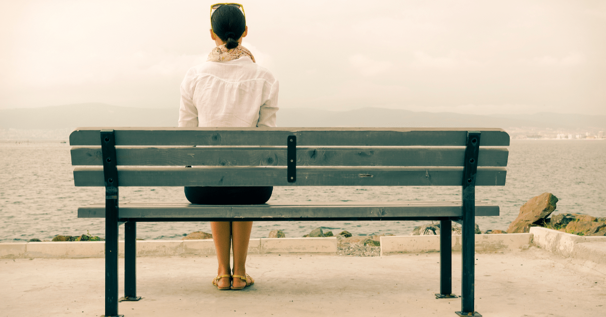 woman sitting on a bench by the sea