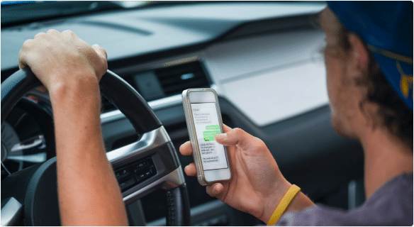 Man pressing his iphone while driving