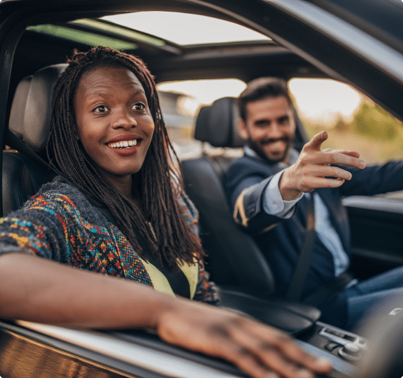 Man and a woman sitting in a car and smiling