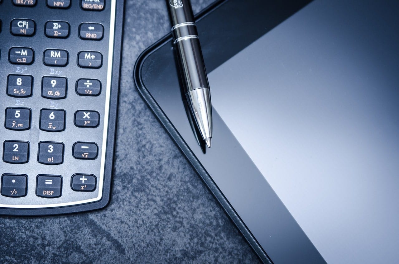 Image of a pen, calculator, and a tablet