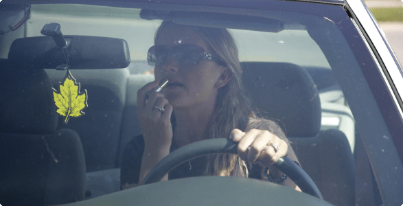 Woman doing her makeup while driving