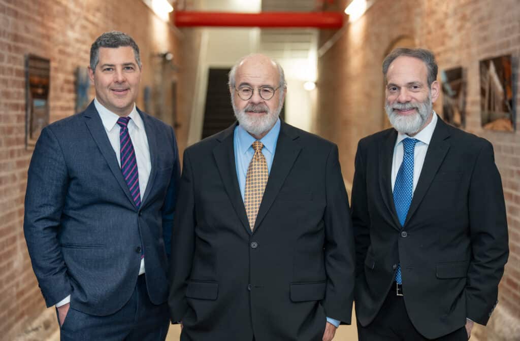 three brown and crouppen partners smiling in their main lobby