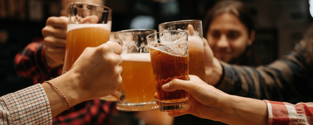 group of people clinking beer glasses together