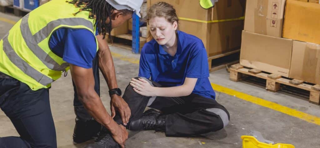 worker holds ankle after slip and fall at work