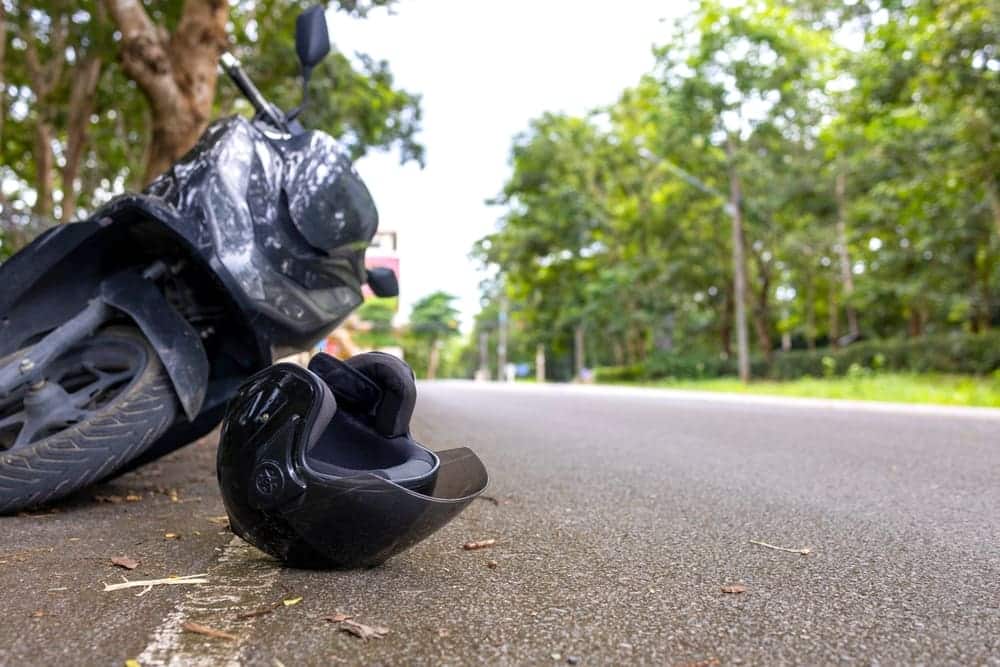 Fallen motorcycle and helmet lying on a road after an accident