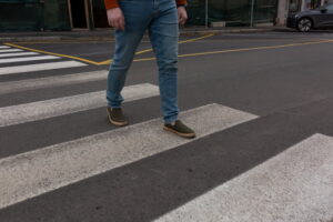 Pedestrian crossing a marked crosswalk on a city street