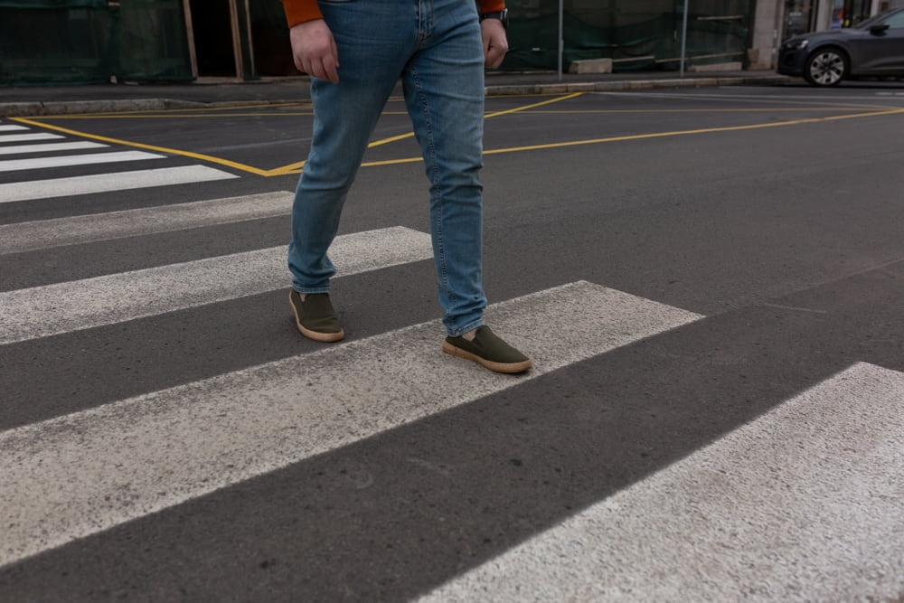 Pedestrian crossing a marked crosswalk on a city street