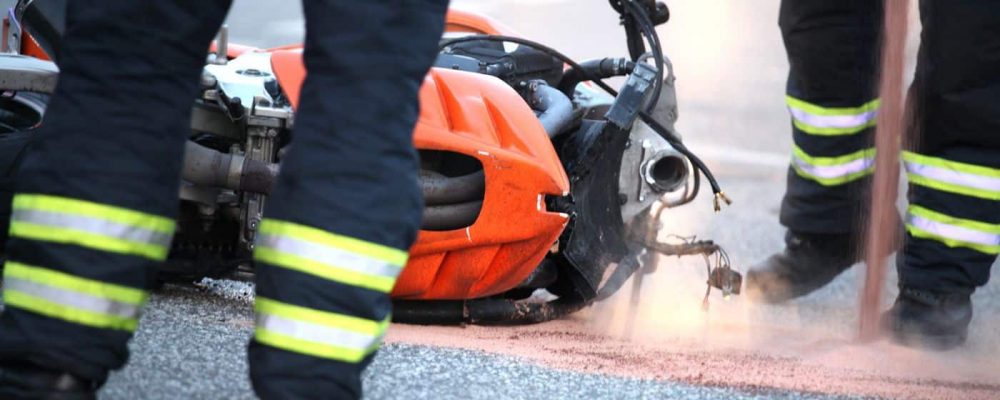 damaged motorcycle laying on the ground after motorcycle accident